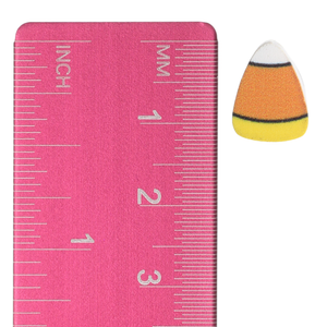 Candy corn stud earring beside an inch and centimeter ruler for size reference