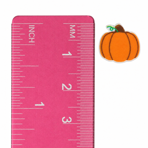 Pumpkin outline stud earring beside an inch and centimeter ruler for size reference