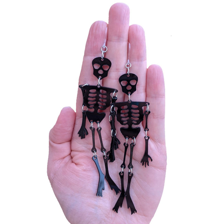 Exaggerated Skeleton Earrings (Dangles) - size comparison hand