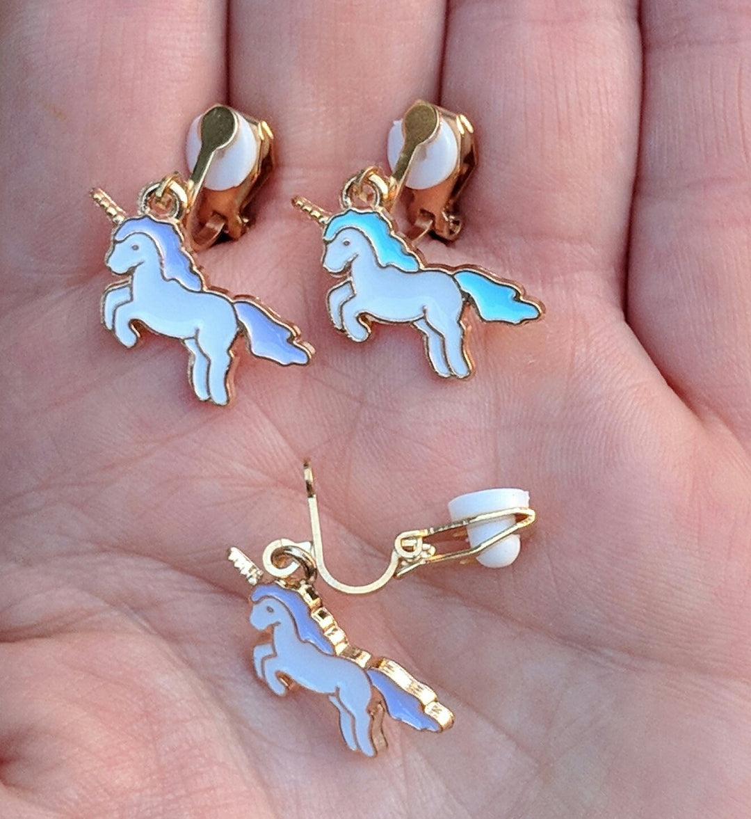 Unicorn Clip-on Earrings - size comparison hand