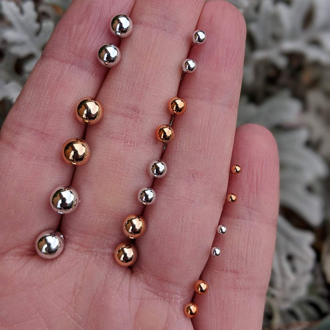 Metallic Pearl Earrings (Studs) - size comparison hand