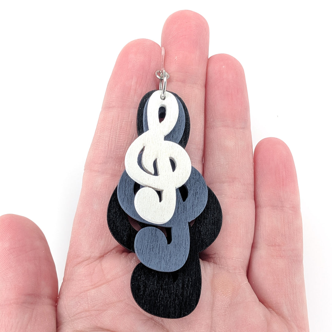 Exaggerated Wooden Triple Treble Clef Earrings (Dangles) - size comparison hand