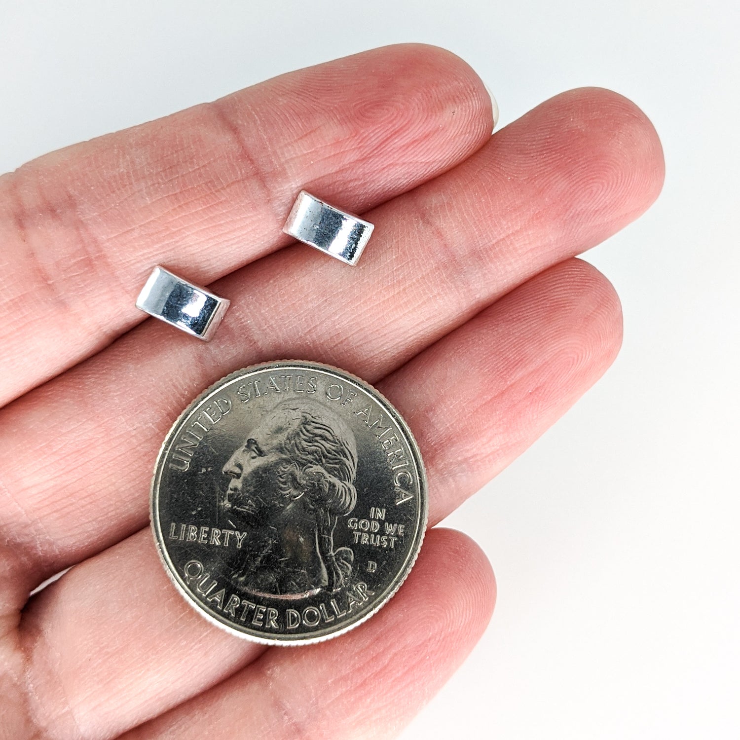 Tiny Arc Earrings (Studs) - size comparison hand and quarter