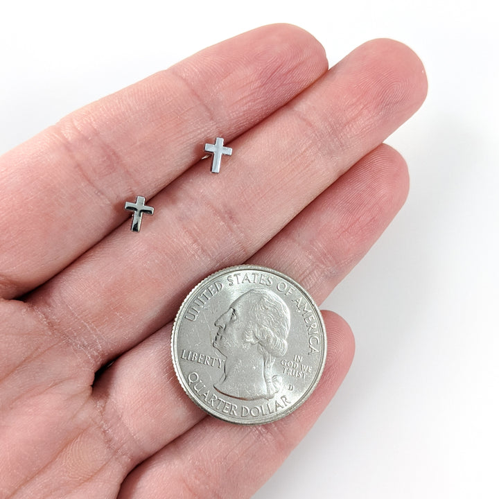 Tiny Silver Cross Earrings (Studs) - size comparison quarter, size comparison hand