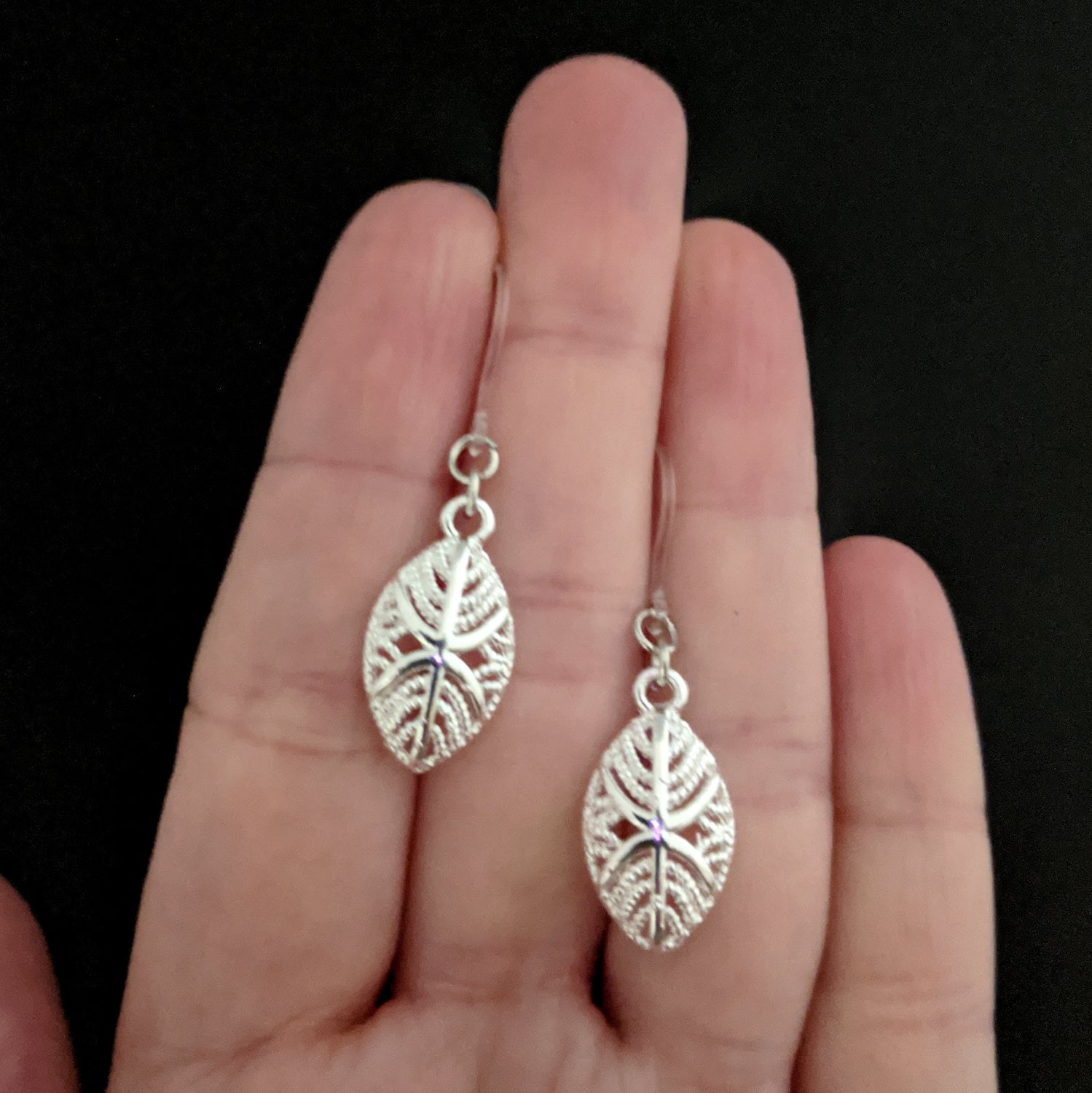 Silver African Mask Earrings (Dangles) - size comparison hand