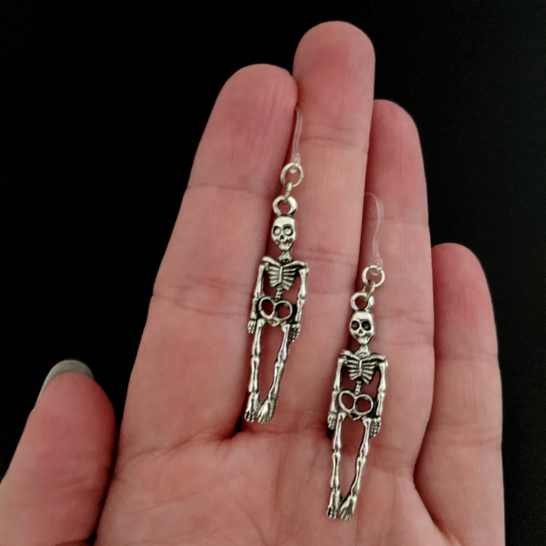 Silver Skeleton Earrings (Dangles) - size comparison hand