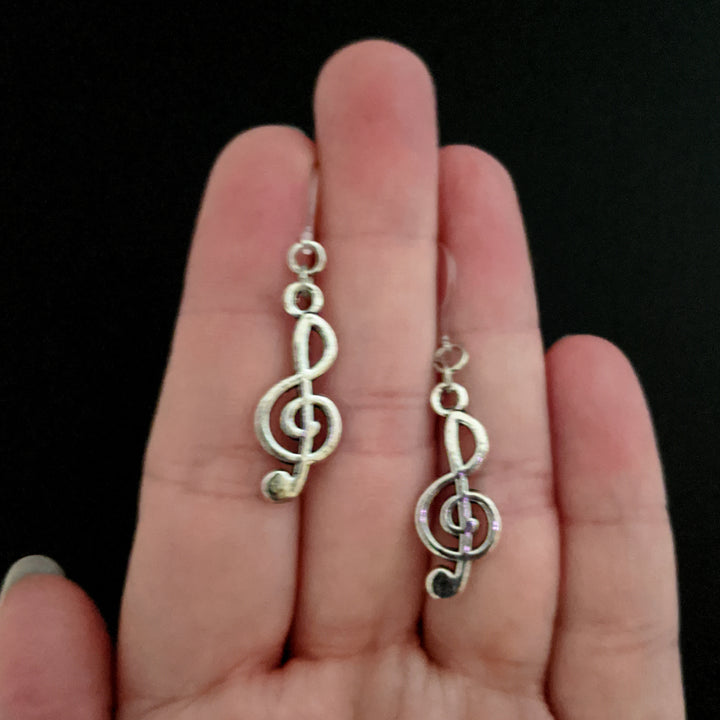 Silver Treble Clef Earrings (Dangles) - size comparison hand