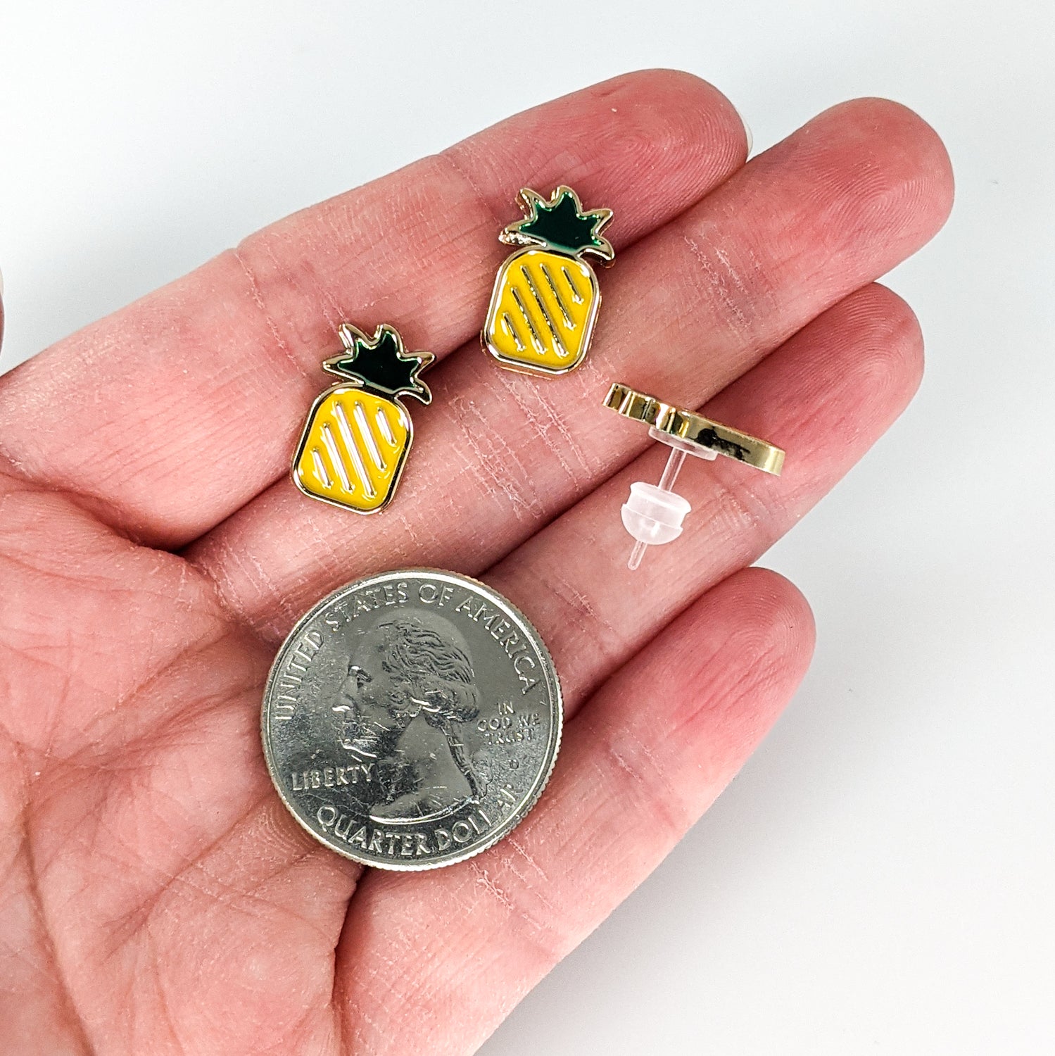 Gold Rimmed Pineapple Earrings (Studs) - size comparison quarter & hand