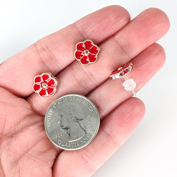 Gold Rimmed Button Flower Earrings (Studs) - size comparison quarter & hand