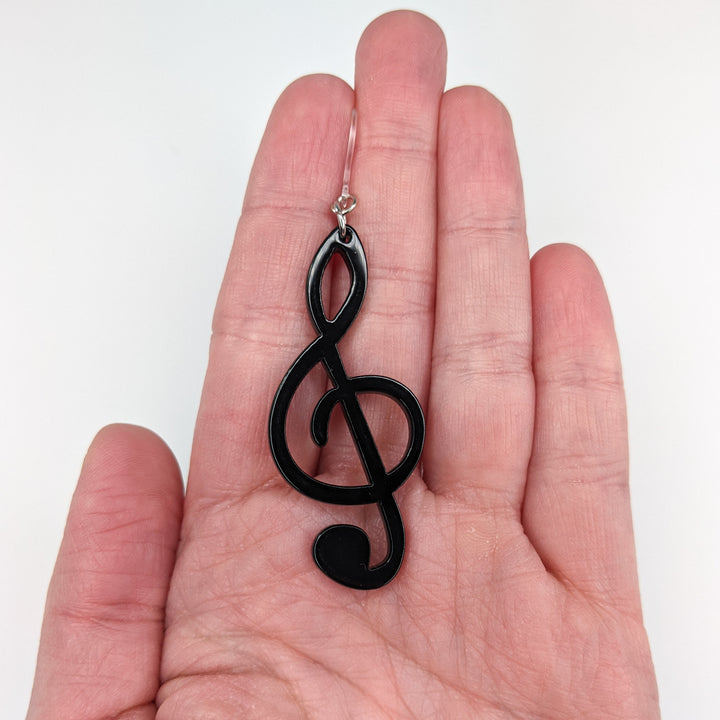 Exaggerated Treble Clef Earrings (Dangles) - size comparison hand