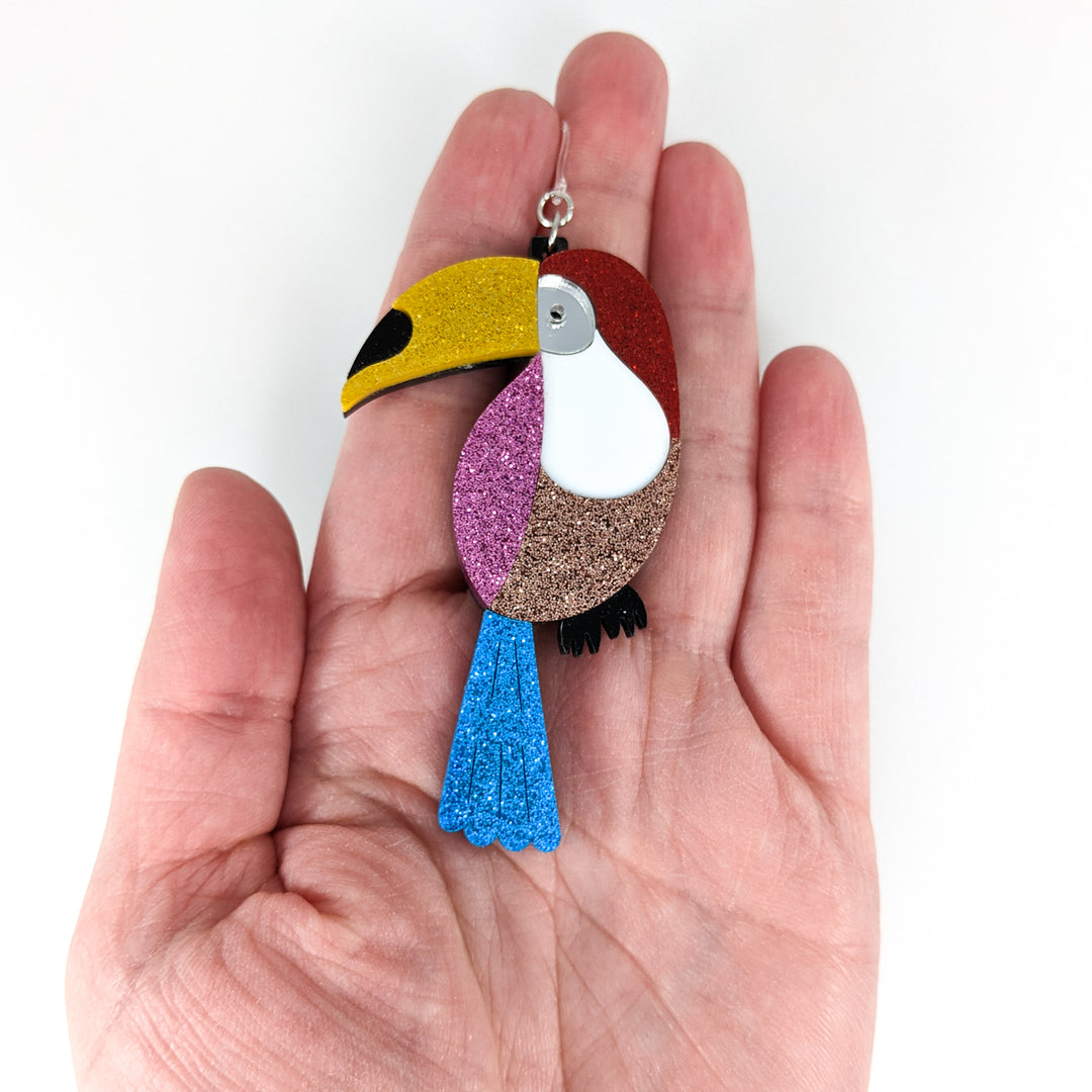 Exaggerated Toucan Earrings (Dangles) - size comparison hand