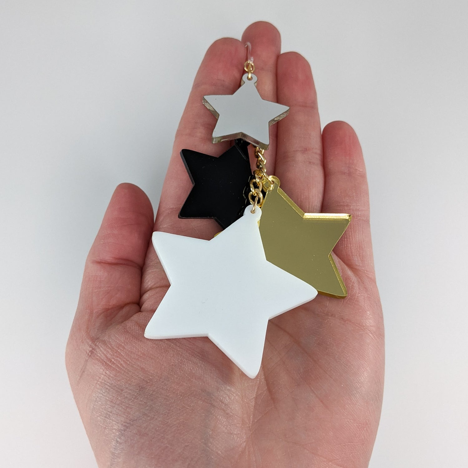 Exaggerated Stars Earrings (Dangles) - size comparison hand