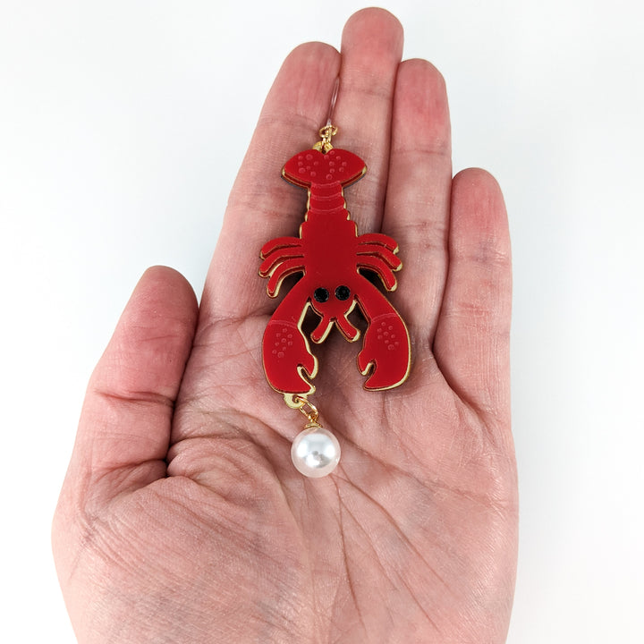 Exaggerated Pearl Lobster Earrings (Dangles) - size comparison hand