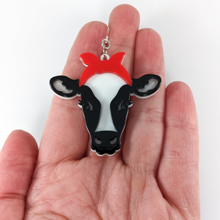 Exaggerated Heifer Earrings (Dangles) - size comparison hand