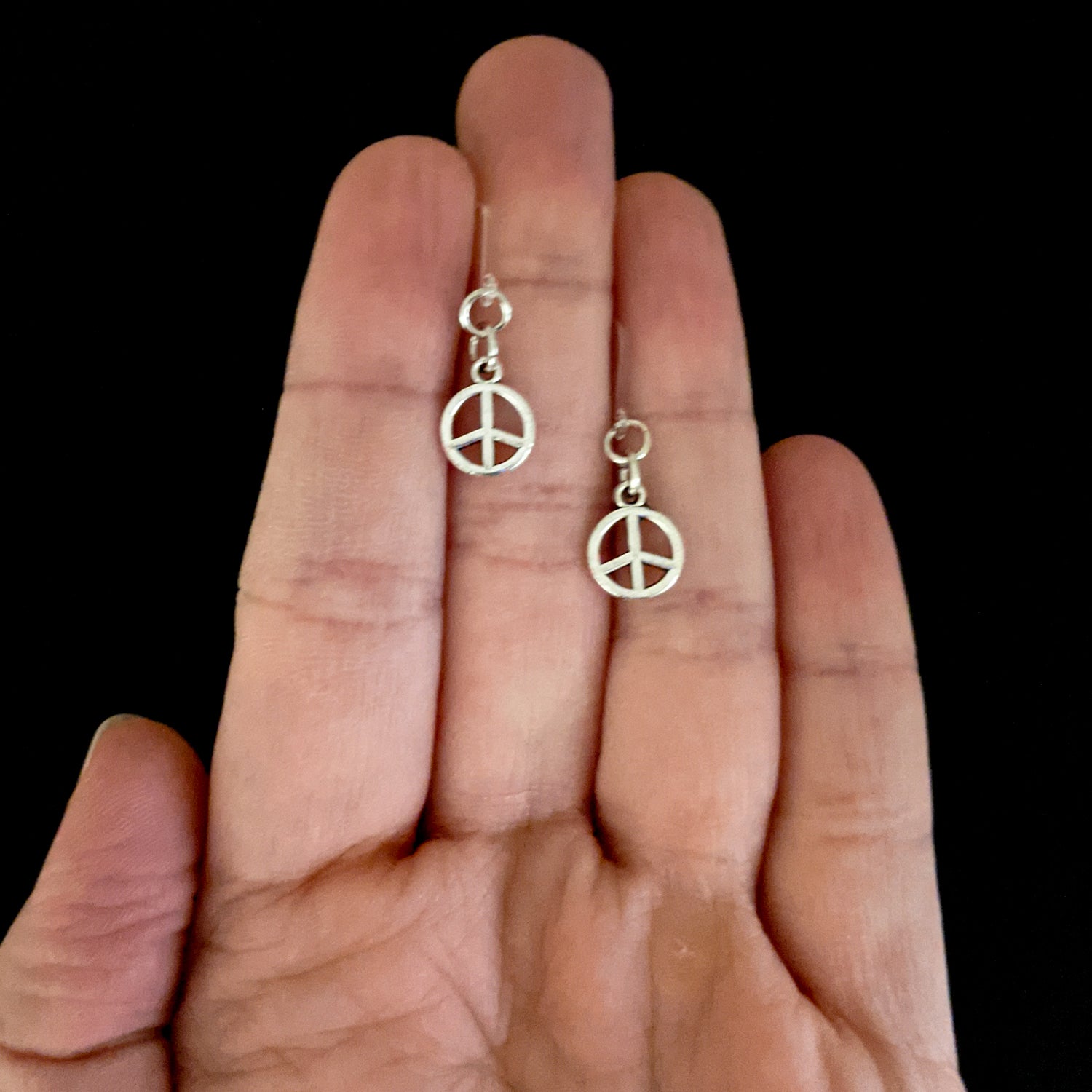 Tiny Peace Drop Earrings (Dangles) - size comp;arison hand