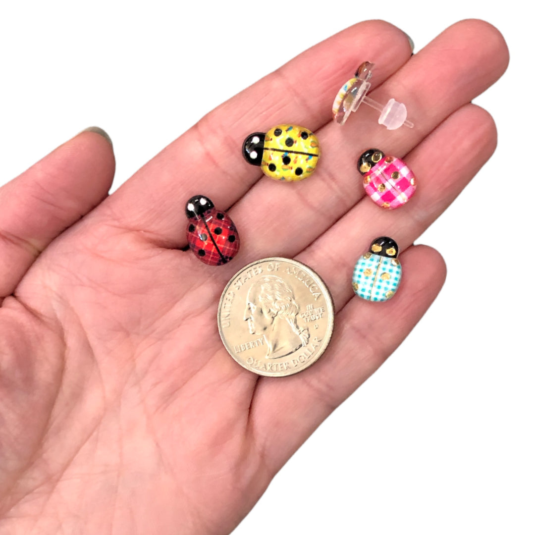 Patterned Glassy Ladybug Earrings (Studs) - size comparison quarter & hand