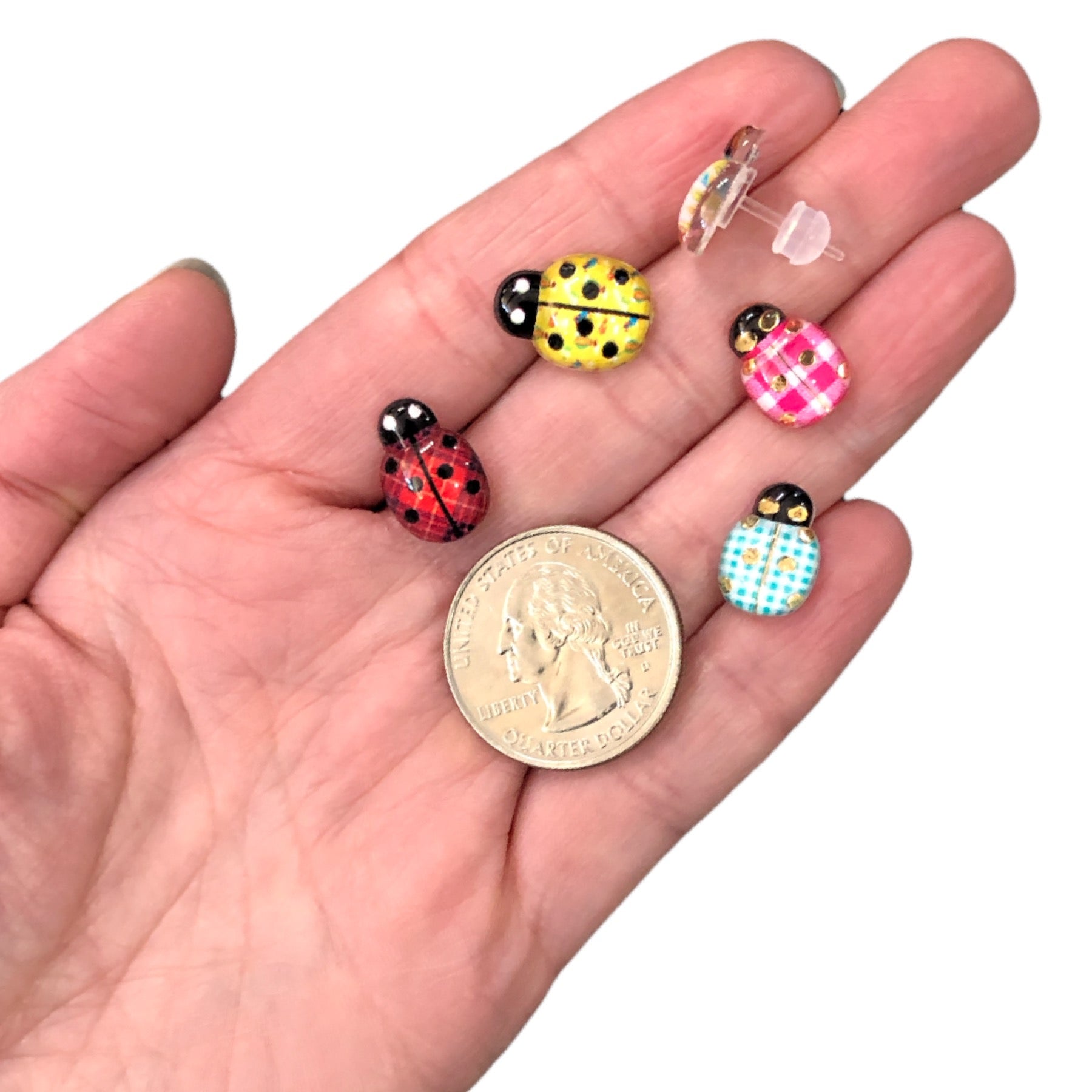 Patterned Glassy Ladybug Earrings (Studs) - size comparison quarter & hand